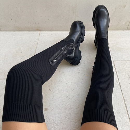 Tall black boots with ribbed shafts, side zippers and lugged soles